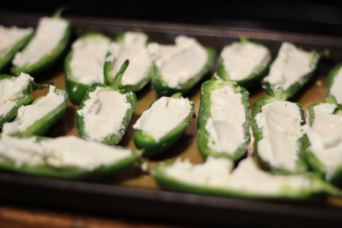 Stuffing the jalapeño peppers with cream cheese.